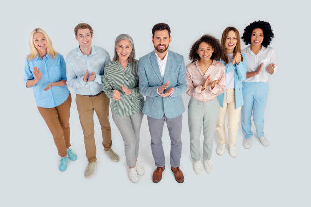 istock Diverse group of professionals standing together and clapping in a cooperative office atmosphere, multi-age 2200853245