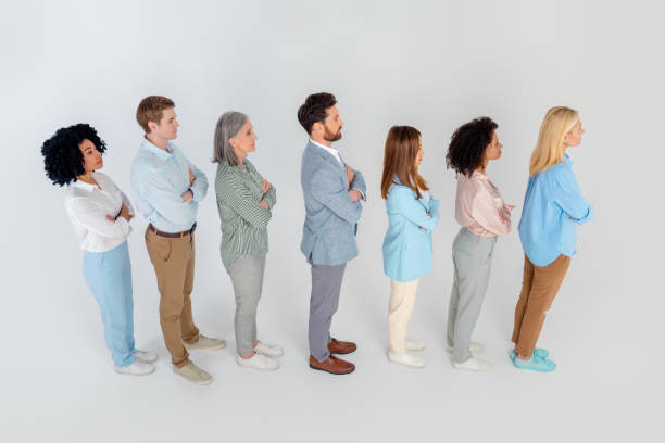 istock Diverse group of professionals standing in a line on a grey background, showcasing unity and teamwork in a corporate environment,  top view 2200853281