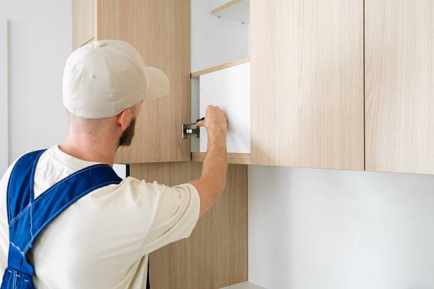 istock Handyman installing shelves in modern wooden kitchen cabinets 2200856377