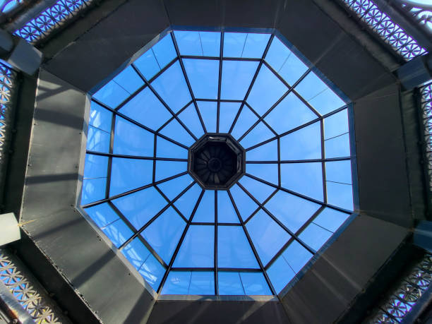 An iron gazebo with a glass ceiling on a blue sky background.