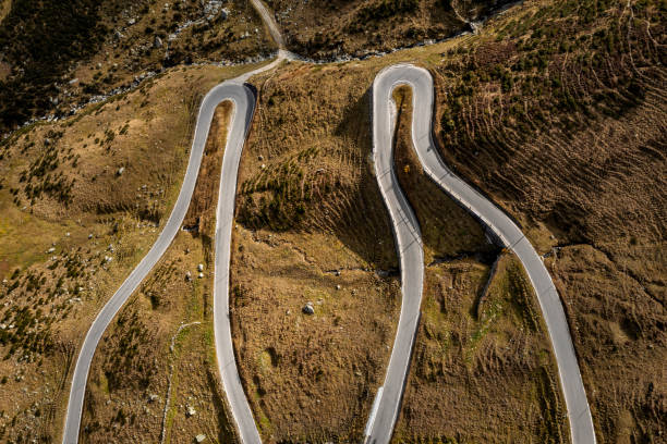 Aerial top-down view of a mountain winding road in the Swiss Alps.