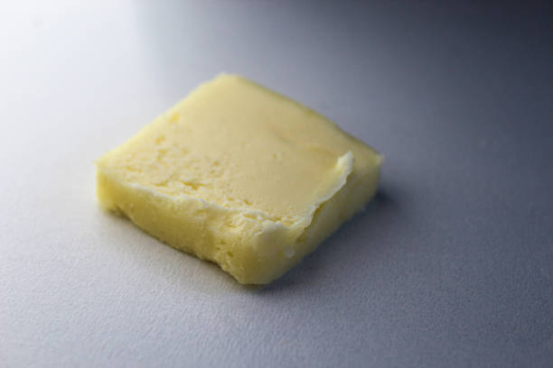 a pat of butter isolated on a white background. flavor texture food staple creamy ingredient design element