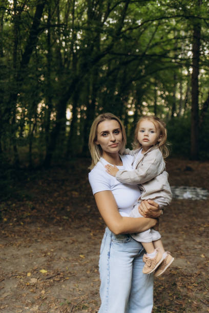 istock Mother and Daughter Embracing In a Tranquil Forest Setting 2200860062