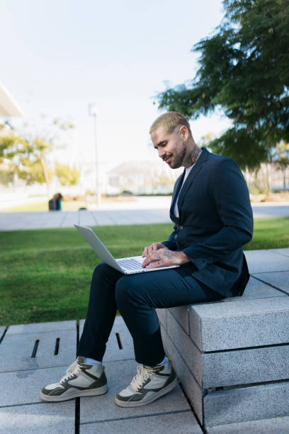 istock Young businessman working on laptop outdoors in urban environment 2200863302