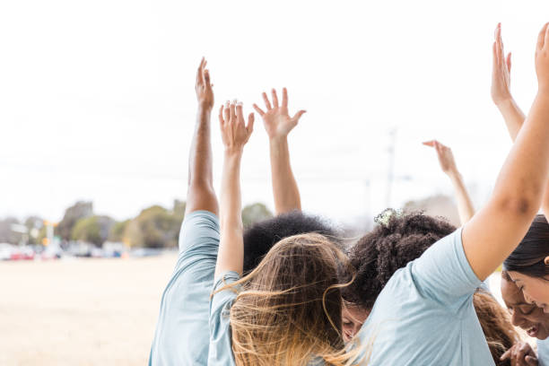 Happy women of different ethnicities celebrating together outdoors.  Real people, genuine joy.