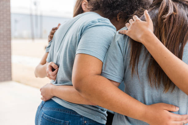 istock Women embracing in a group hug, showing support and friendship 2200866907