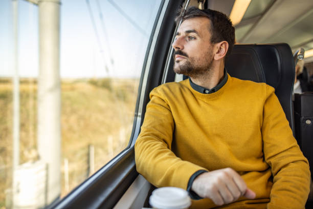 istock Traveler man enjoying the view through the train window 2200867865
