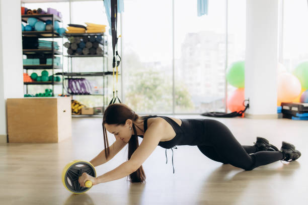 istock Young Woman Using Ab Wheel in Modern Gym Setting for Exercise 2200869545