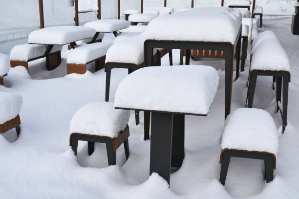 istock Tables and chairs covered with white snow 2200869641