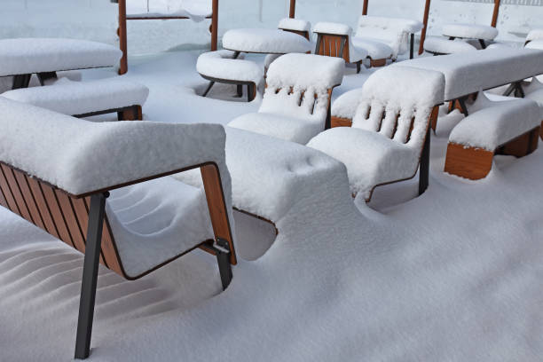 istock Tables and chairs covered with white snow 2200869645