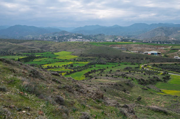istock Rolling green hills under a cloudy sky with distant mountains in a serene countryside landscape 2200869782