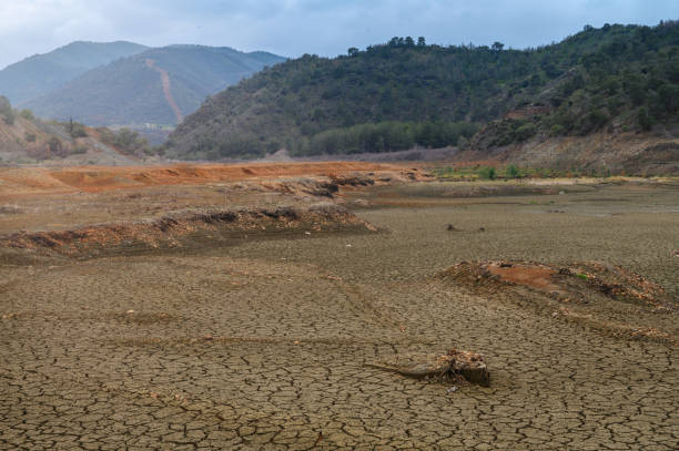 istock Dry earth reveals cracks in the landscape under a cloudy sky at a remote valley 2200869785