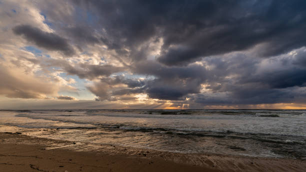 istock Waves crash against the shore, mirroring the turbulent sky above Haifa. 2200870166