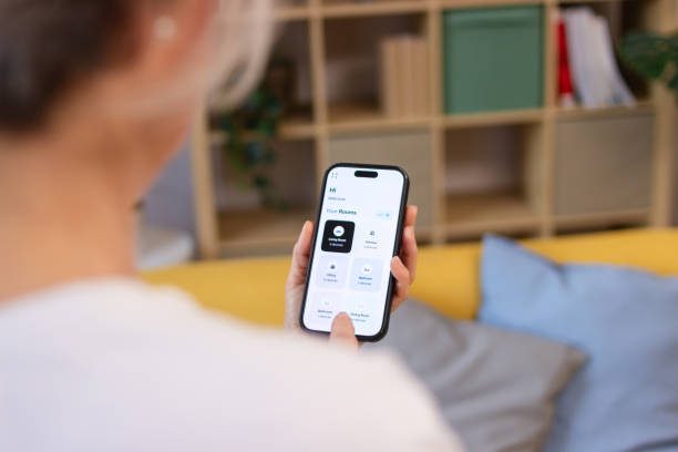 istock Woman using smart home app on mobile phone to control room devices 2200876124
