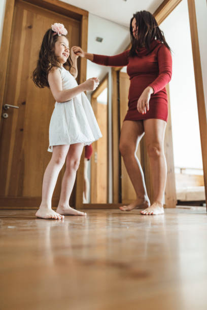 istock mother and daughter dancing at home 2200876184