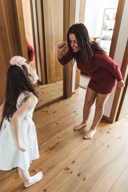 istock mother and daughter dancing at home 2200876760