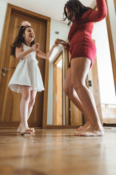 istock mother and daughter dancing at home 2200876903