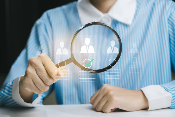 istock Person Using Magnifying Glass to Analyze Data and Profiles 2200879388
