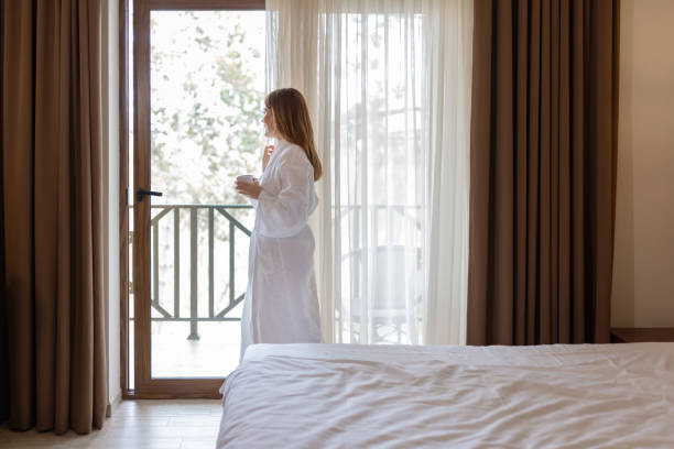 istock Peaceful Morning – Woman in a White Bathrobe Sipping Coffee 2200881855