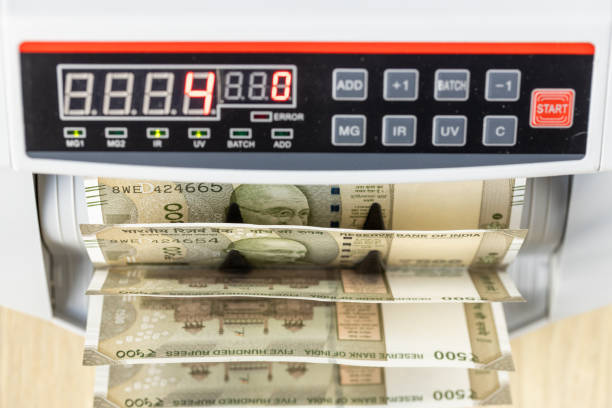Indian Rupees currency paper notes cash stack of INR 500 - Money placed or put in, inserted vibrant orange yellow gifting envelope over horizontal red maroon background with copy space. Can be used as money lending, shopping, shagun lifafa gifts, investments related backdrops.