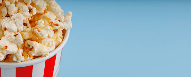 istock Classic red striped popcorn cardboard cup on blue background 2200884897