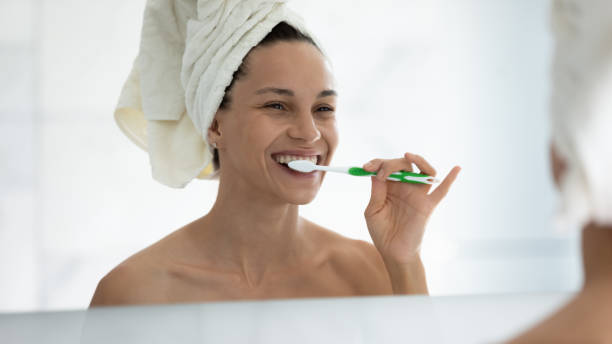 istock Smiling young woman clean teeth with toothbrush in bath 2200888486