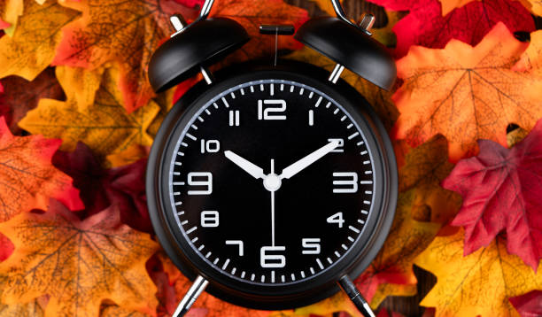 istock Classic desktop alarm clock and  autumn leaves 2200890733