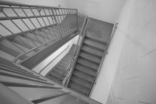 Concrete stairway in residential building looking down. Black and white.