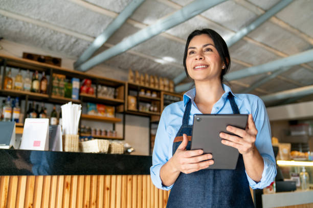 istock Happy waitress working at a cafe and holding a digital tablet 2200892631