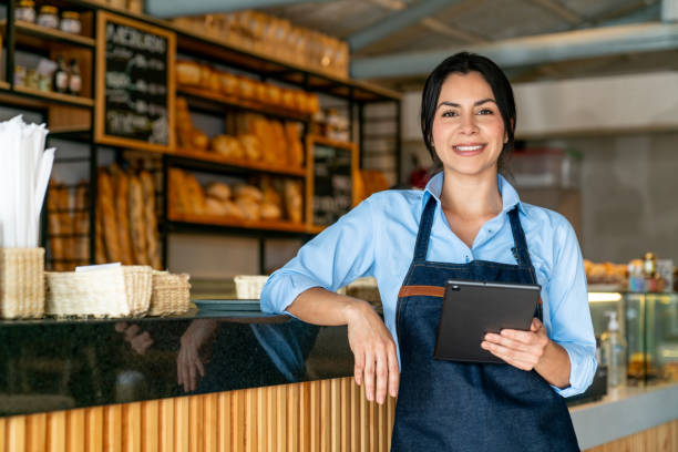 istock Happy waitress working at a coffee shop and holding a digital tablet 2200892635