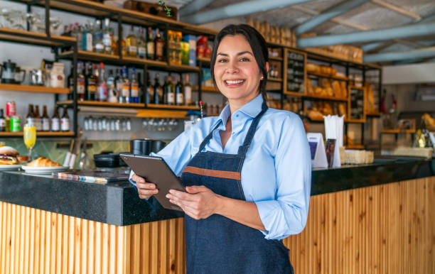 istock Portrait of a happy waitress working at a cafe using a digital tablet 2200892680