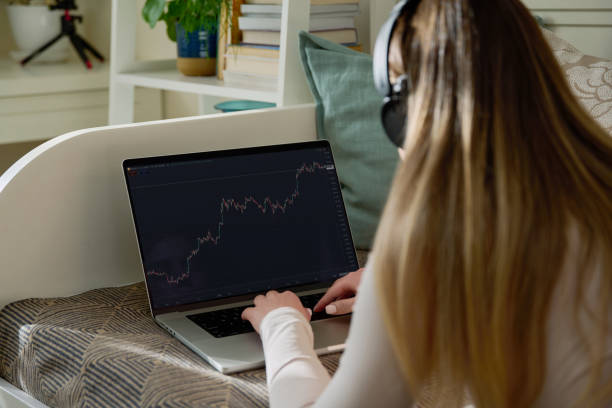 istock Laptop screen with market analysis charts, woman working on computer, rear view 2200894124