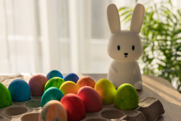 istock Celebrating Easter with colorful eggs and a cute bunny figure in spring sunlight 2200895406