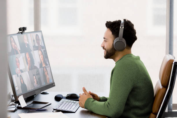Man in Video Conference Meeting Using Wireless Headphones and Laptop