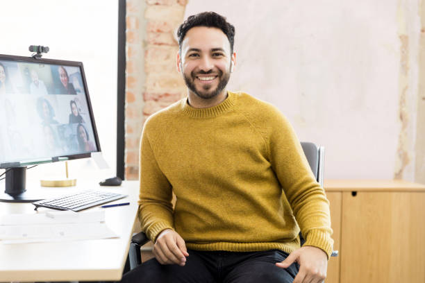 istock Smiling Man in Yellow Sweater on Video Conference Call 2200897755