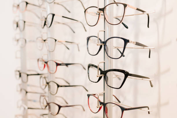 istock Customer chooses eyeglasses with clear lenses from the shelf. Eyesight correction. Stand of eyeglasses with different frames in the optical store. 2200898113