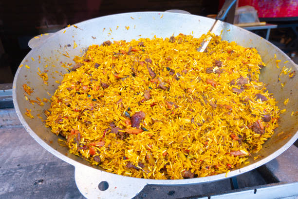 Street food. Large vat of pilaf at an open-air food court in an amusement park (close-up)