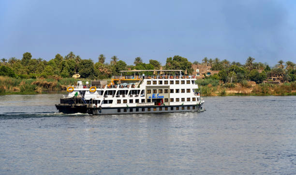 Esna, Egypt, April 14, 2023: A cruise ship sails down the Nile River on a hazy spring morning.