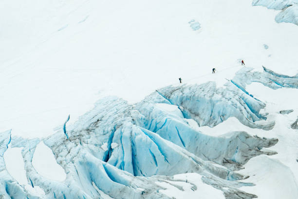 The texture of this glacier is not smooth, but rather massive crevices and mountains of ice. Nobody is going to land a helicopter here! Deep blue color is from pressure driving out oxygen from the ice.