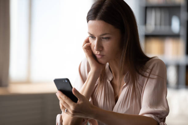 istock Upset woman holds smartphone feels concerned about received message 2200907786
