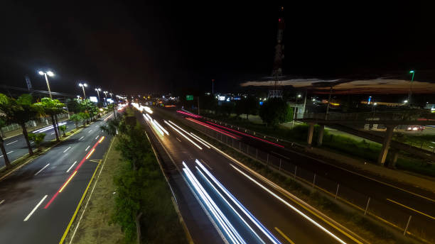 Marilia, Sao Paulo, Brazil, February 19. 2025. traffic on the Highway and silhouette of a telecommunications antenna in Marilia city, during a sunset