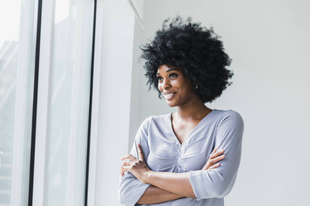 istock Confident African American Woman Smiling by Window 2200908371