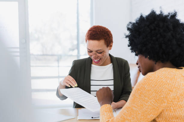 istock Two Diverse Women Reviewing Documents Together in Office 2200908377