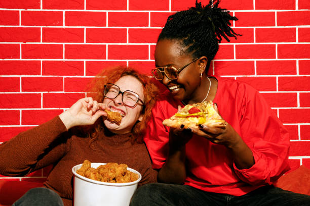 istock Two Friends Laughing and Enjoying Fast Food 2200910938