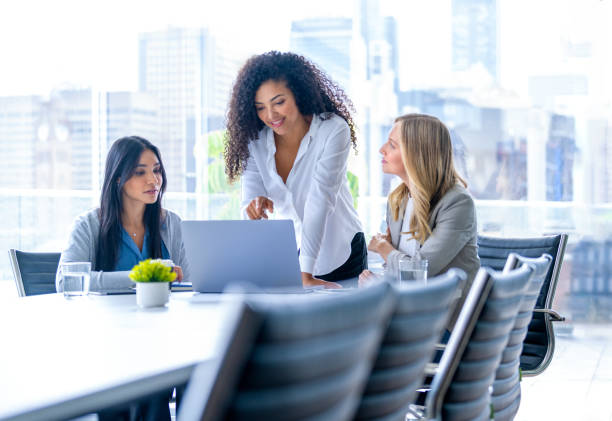 istock Three business  women meeting. They are discussing something while looking at a laptop computer. 2200912797