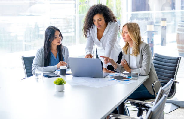istock Three business  women meeting. They are discussing something while looking at a laptop computer 2200912828