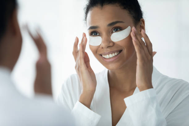 istock Biracial young woman apply under eye patches in bath 2200921411