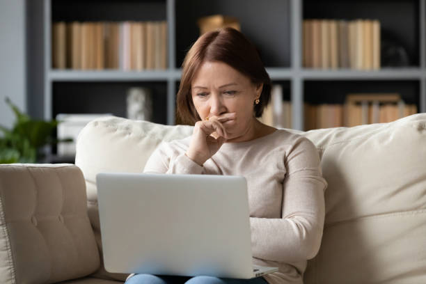 istock Elderly woman looking at laptop screen having difficulties with usage 2200921970