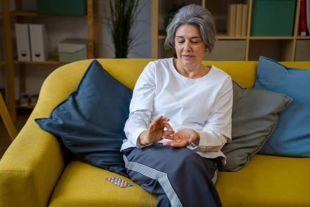 istock Senior woman taking medicine pills 2200923621