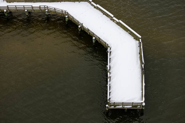 Birdseye and overhead view of Bridge in Hampton Roads covered in snow surronded by water